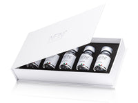 Set of INFINI skincare bottles in a white box on a white background